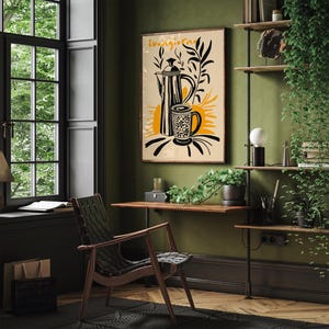 Pu&ograve; includere: Un'illustrazione in bianco e nero di una caffettiera e una tazza con il testo "Buongiorno" su uno sfondo beige. L'illustrazione &egrave; incorniciata e appesa a una parete verde.