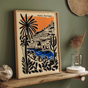 May include: A framed art print featuring a stylized illustration of Porto, Portugal. The artwork showcases a coastal scene with buildings, palm trees, and a blue body of water, set against an orange and beige backdrop. The words "Porto, Portugal" are at the top.