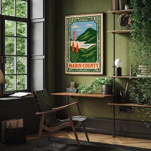 May include: A framed poster depicting Marin County, with a stylized image of the Golden Gate Bridge, hills, and water. The poster has a green and cream border and the words "Marin County" in a red oval. It hangs on a green wall.