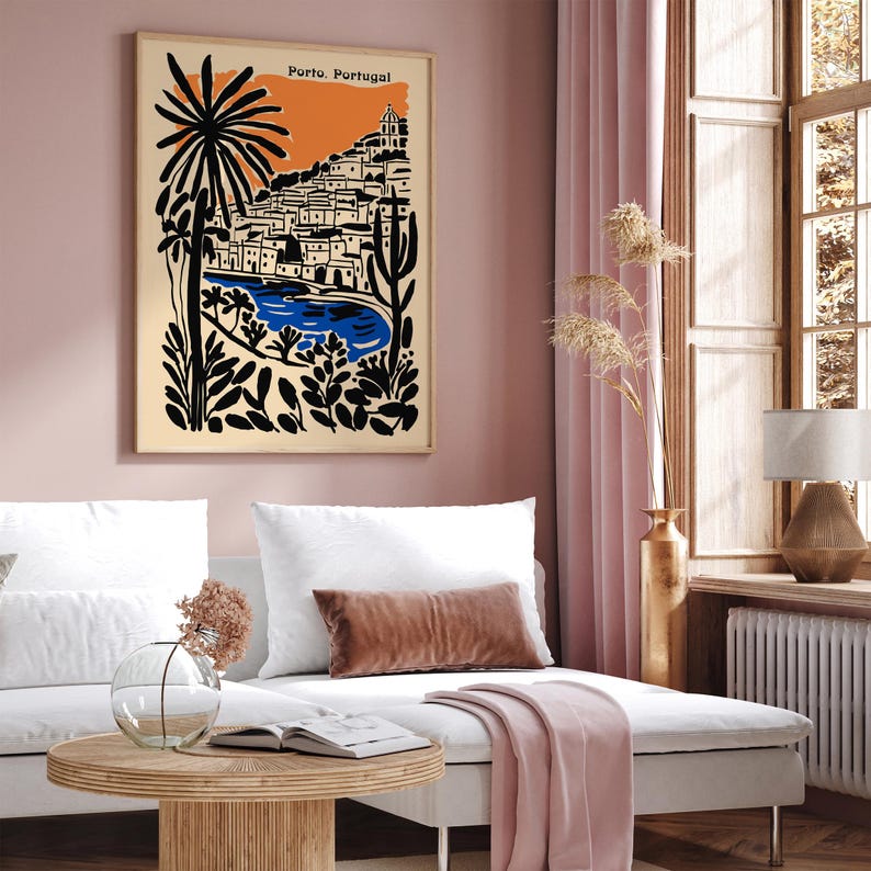 May include: A framed art print featuring a stylized illustration of Porto, Portugal. The artwork showcases a coastal scene with buildings, a blue body of water, and a vibrant orange sky. The text "Porto, Portugal" is printed at the top.