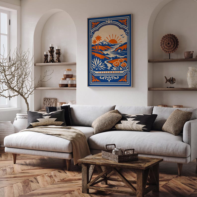 May include: A rectangular wall art print featuring a stylized California landscape with a rising sun, palm trees, mountains, and poppies in shades of blue, orange, and cream. The word CALIFORNIA is printed in a decorative frame at the bottom.