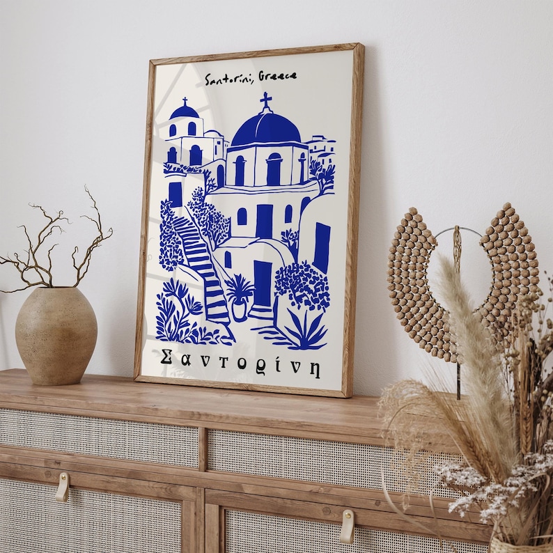 Puede incluir: Una ilustraci&oacute;n azul y blanca de una iglesia en Santorini, Grecia. El texto "Santorini, Grecia" y "&Sigma;&alpha;&nu;&tau;&omicron;&rho;ί&nu;&eta;" est&aacute; impreso en el p&oacute;ster.