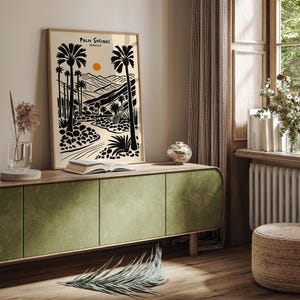 Pode incluir: Ilustra&ccedil;&atilde;o em preto e branco de uma paisagem des&eacute;rtica com palmeiras e um sol poente. O texto "Palm Springs, Calif&oacute;rnia" est&aacute; no topo da imagem.