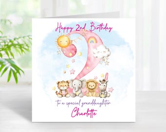 Può includere: Biglietto di compleanno con un numero 2 rosa, un sole sorridente e un arcobaleno. La carta presenta un design ad acquerello con una tigre, un elefante, un leone e una zebra. Il testo recita "Happy 2nd Birthday" e "To a special granddaughter Charlotte."