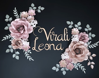 May include: A decorative floral arrangement featuring large paper roses in shades of mauve and blush, accented with white and green leaves. The arrangement is set against a dark background and includes the text "Virali Leona" in a cursive font.