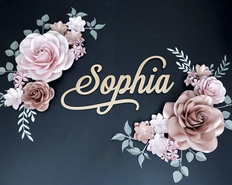 May include: A paper flower arrangement with the name "Sophia" in cursive script. The flowers are in shades of pink and brown, with green leaves.