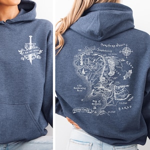May include: A blue hoodie with a front graphic of a sword and the text "I AM NO MAN". The back features a detailed map with text including "Dokchery Wasch" and "The Sundering Seas".