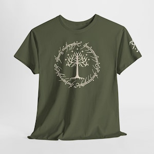 Peut inclure: T-shirt vert olive avec un motif d'arbre blanc dans une inscription circulaire. Le design est sur le thème de la fantaisie. Le t-shirt à manches courtes est fait d'une matière douce.
