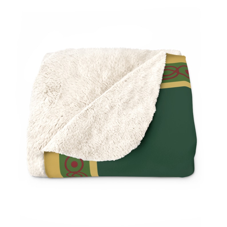 May include: A soft, plush throw blanket with a green and gold design. The blanket has a white sherpa lining and features a repeating pattern of circles and lines.