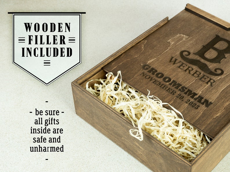 May include: A wooden box with a lid, filled with wood shavings. The lid is engraved with the text "GROOMSMAN" and "NOVEMBER 20, 2023" along with the name "WERBER" and the letter "B".