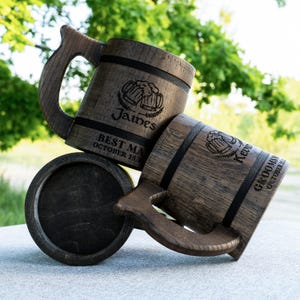 May include: Two wooden beer mugs with handles. The mugs are engraved with the text "Best Man" and "Groomsman" along with the names "James" and "Kevin" and the date "October 25th".