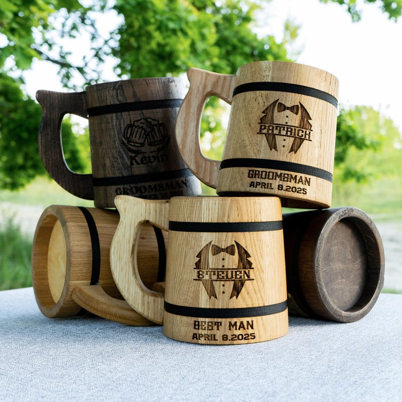 May include: Four wooden beer steins with engraved designs. The steins are decorated with black bands and feature the words "Groomsbman", "Best Man", and names like "Patrick" and "Steven".