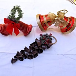 May include: Three sets of Christmas bells, one set is red with a green wreath and red bow, another set is red and gold with a gold bow, and the last set is brown with a green wreath and red bow.