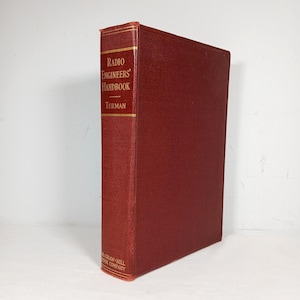 May include: A vintage red hardcover book titled "Radio Engineers' Handbook" by Terman. The book's spine features gold lettering and a gold border. The McGraw-Hill Book Company logo is at the bottom.