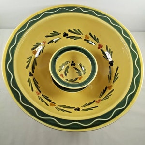 Op de afbeelding: Een gele keramische serveerschaal met een kleinere schaal in het midden. De schalen hebben een groene en witte rand en zijn versierd met een bloemenpatroon.