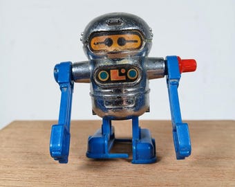 Robot andante de cuerda Tomy Acrobot de 1979, n.° 2521, color plata y azul, en buen estado de funcionamiento.