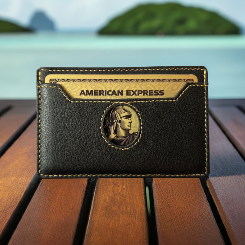 May include: A black leather card holder with a gold trim and the words "AMERICAN EXPRESS" embossed on the front. The card holder features a gold medallion with a Roman soldier design.