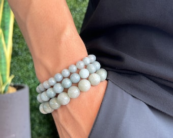 May include: Three beaded bracelets in varying sizes, featuring light green and white stones. The bracelets are worn on a wrist, with a model wrist size of 7 inches (L) visible in the image. The bracelets are a light green color.