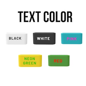 May include: Five rectangular silicone bands arranged in two rows. The top row features a white band with black text, a black band with white text, and a teal band with pink text. The bottom row shows a yellow band with green text and a green band with red text.