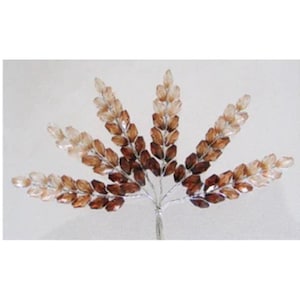 May include: A decorative floral stem featuring a fan-like arrangement of brown and tan crystal beads. The beads are clustered to resemble wheat or leaves, attached to a silver wire stem. Ideal for crafting or embellishing.