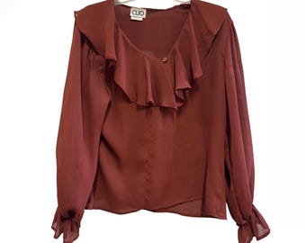 Blusa vintage Clio color óxido con volantes y escote en V, manga larga, color terracota, talla mediana.