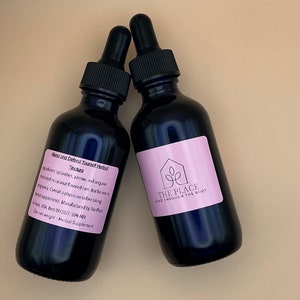 Puede incluir: Dos botellas de vidrio azul oscuro con goteros, etiquetadas con "Mend and Defend Yourself Herbal Tincture" y "The Place Where Mind Through The Body".
