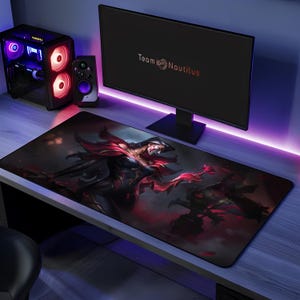 May include: A black and red gaming mouse pad with a female character wearing a mask and a red and black outfit. The mouse pad features the text "Team Nautilus".