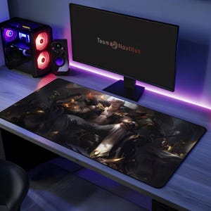 May include: A rectangular desk mat featuring a dark, detailed illustration of a muscular character with horns sitting on a throne. The mat is positioned on a desk in front of a computer monitor displaying the text Team Nautilus in a white font.
