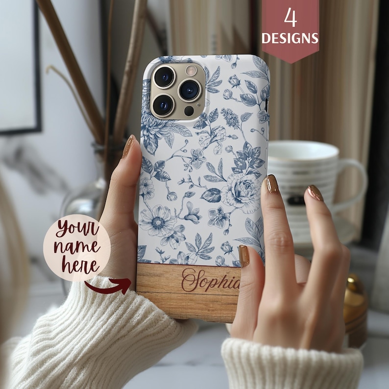 May include: A white phone case with a blue floral pattern and a wood panel at the bottom with the name "Sophia" engraved on it.