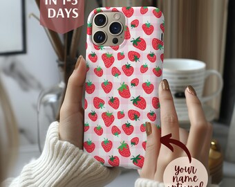 May include: A phone case featuring a pattern of red strawberries with green leaves on a pink and white checkered background. The case is held in a person's hands. Text on the case says "Your name optional".