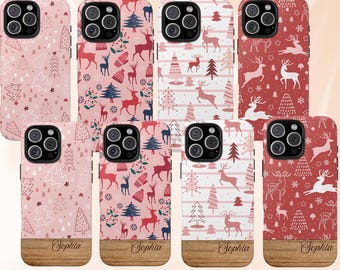 Puede incluir: Ocho fundas de teléfono con diseños navideños. Las fundas presentan patrones de ciervos, árboles de Navidad y copos de nieve en tonos rosa, rojo y blanco. Cada funda tiene una base con aspecto de madera y el nombre "Sophia" impreso.