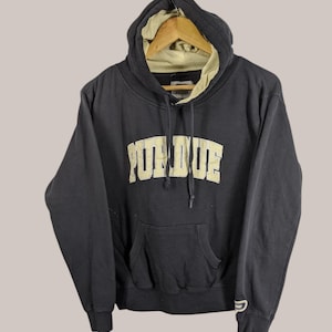 May include: Black hooded sweatshirt with a gold embroidered "Purdue" logo on the front. The sweatshirt has a kangaroo pocket and a drawstring hood.