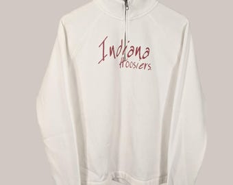 Może przedstawiać: Biała bluza z długim rękawem i półzamkiem. Bluza ma haftowany czerwony i biały napis "Indiana Hoosiers".