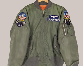 Chaqueta MA-10 de la Fuerza Aérea de EE. UU. estilo bomber vintage desgastada, chaqueta Tom Cat de la Fuerza Aérea, cuello redondo, parche con logo de la Fuerza Aérea de los Estados Unidos, color verde, talla L