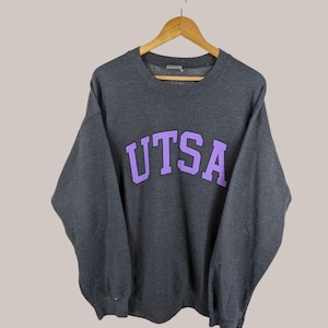 May include: A dark grey sweatshirt with a purple "UTSA" logo printed on the front.