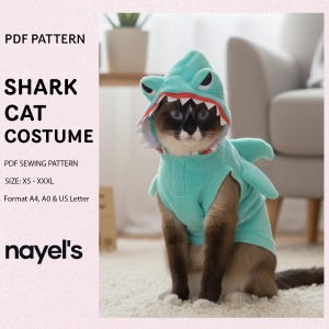 Op de afbeelding: Een kat in een turquoise haaienkostuum met een kap en vin. Het kostuum heeft een rood gevoerde mond met witte tanden. Tekst links luidt "SHARK CAT COSTUME" en "PDF SEWING PATTERN". Maten: XS tot XXXL.