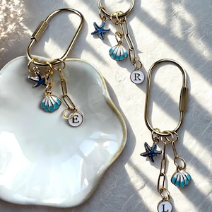 Blue coastal tote bag charm with enamel seashell and starfish, engraved ‘Last Toast On the Coast’, ideal for bachelorette favors or beach-themed accessories