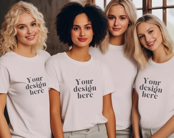May include: Four women wearing white t-shirts with the text "Your design here" printed on the front. The women are standing in front of a window with a brick wall behind them.