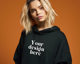 May include: A black hooded sweatshirt with the text "Your design here" printed in white on the front.