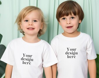 May include: Two children wearing white t-shirts with the text "Your design here" printed on the front. The children are standing in front of a green background.