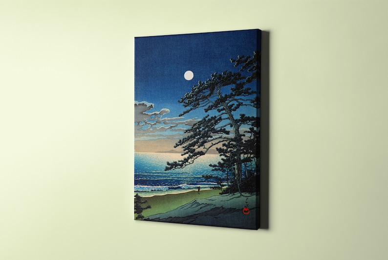 Puede incluir: Una impresi&oacute;n en lienzo de una serena escena costera nocturna. La obra representa una luna llena en un cielo azul oscuro, un pino silueteado y una playa de arena con suaves olas. La paleta de colores incluye azules, verdes y blancos.