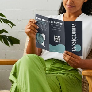 May include: A person is sitting in a chair and reading a tri-fold brochure with the words "Welcome" and "Follow Us" on the front. The brochure also includes a QR code and social media handles.