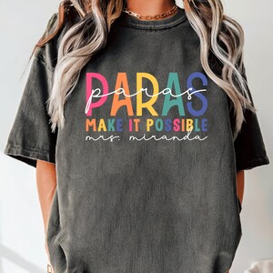 May include: A black t-shirt with the text "paras make it possible mrs. miranda" in rainbow colors.