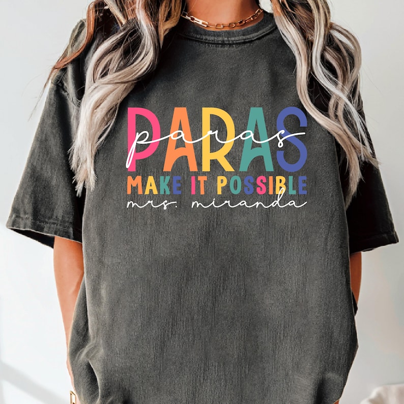 May include: A black t-shirt with the text "paras make it possible mrs. miranda" in rainbow colors.