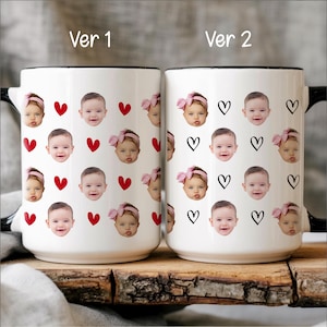 May include: Two white ceramic mugs with black rims and handles. One mug features red hearts and baby faces, the other has black heart outlines and baby faces. The text "Ver 1" and "Ver 2" are above the mugs.