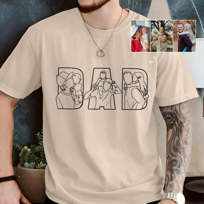 Peut inclure: T-shirt beige avec le mot "DAD" en lettres grasses et soulign&eacute;es. Chaque lettre pr&eacute;sente un dessin au trait noir d'un parent avec un enfant. De petites photos suppl&eacute;mentaires montrent des moments similaires parent-enfant. Un t-shirt d&eacute;contract&eacute;.