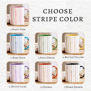 May include: A selection of ceramic mugs with vertical stripe designs in various colors, including dusty pink, baby blue, sage green, butter yellow, muted lilac, orange, and warm brown. The text "CHOOSE STRIPE COLOR" is displayed.
