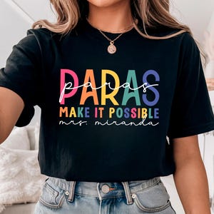 May include: Black t-shirt with a rainbow colored graphic that says "paras make it possible mrs. miranda".