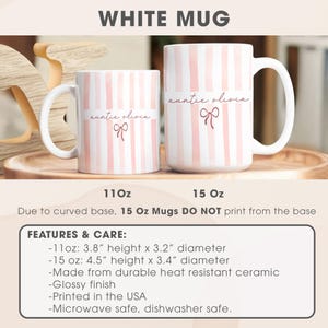 May include: White ceramic mugs with pink vertical stripes. The mugs have the text "auntie olivia" and a bow graphic. The smaller mug is 3.8" high and 3.2" in diameter, while the larger mug is 4.5" high and 3.4" in diameter. The mugs are microwave and dishwasher safe.