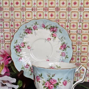 Vintage Aynsley "Grotto Rose" himmelsblå variantmönster. Tekopp och fat med fot, duo, cirka 1960-talet